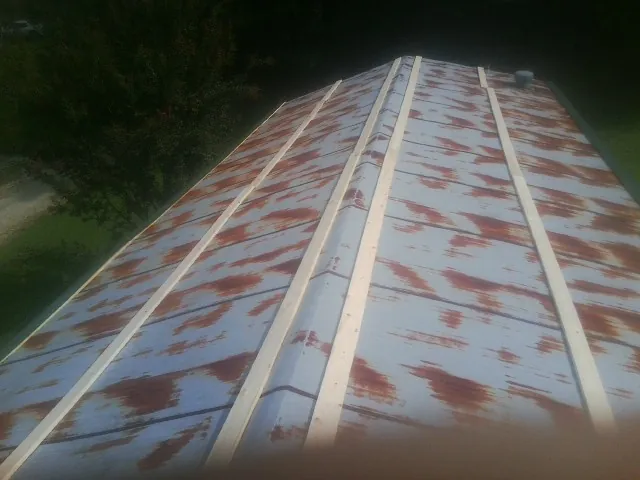 Rusted metal roof panels with new wood purlins before replacement — Storm Damage Roof Repair in Ragland by Roofing Brothers