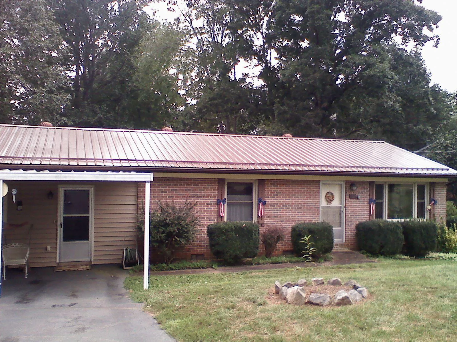 Bronze metal roof and carport on a brick ranch home — Roof Repair work by our crew in Ragland